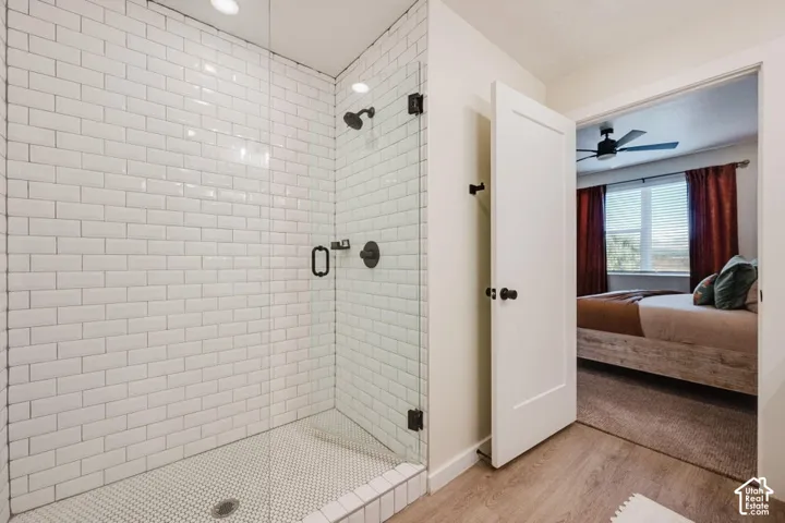 Walk-in shower featuring white subway wall tile, hexagonal floor tile, a glass enclosure, and matte black hardware
