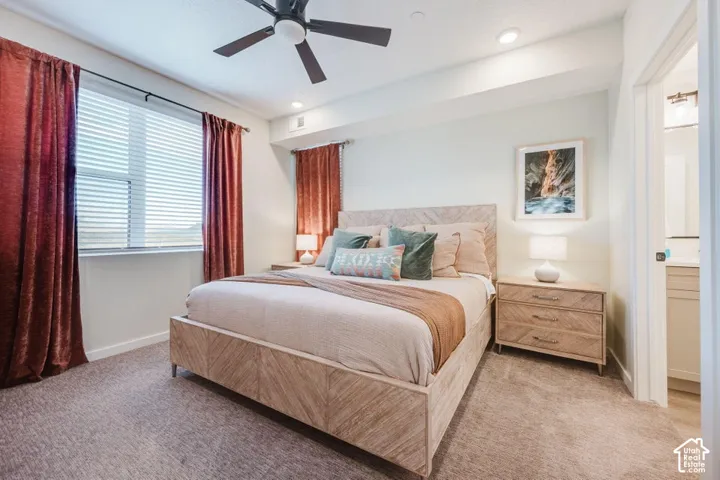 Bedroom featuring neutral wall-to-wall carpeting, a matte black ceiling fan, recessed lighting, and multiple windows with horizontal blinds