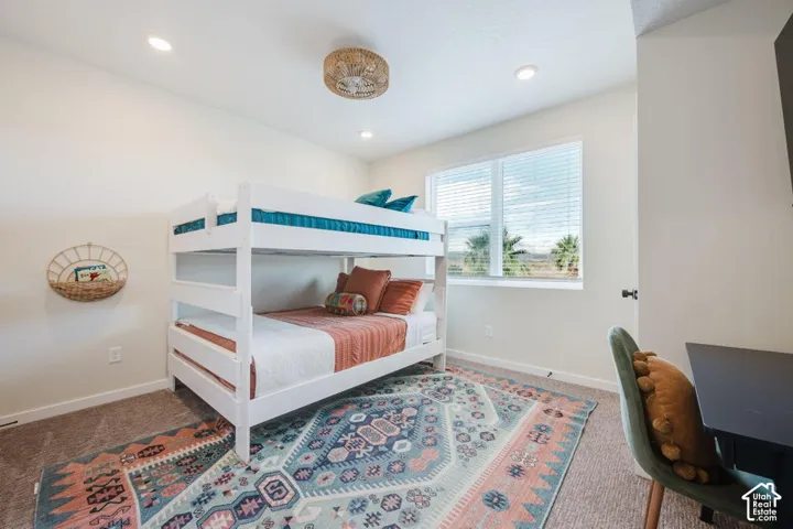 Neutral-toned carpeted room featuring recessed lighting, a textured semi-flush mount ceiling fixture, and a large window with horizontal blinds