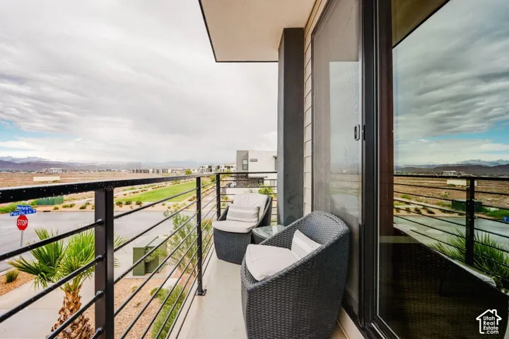 Covered balcony featuring horizontal metal railing and floor-to-ceiling glass sliding door