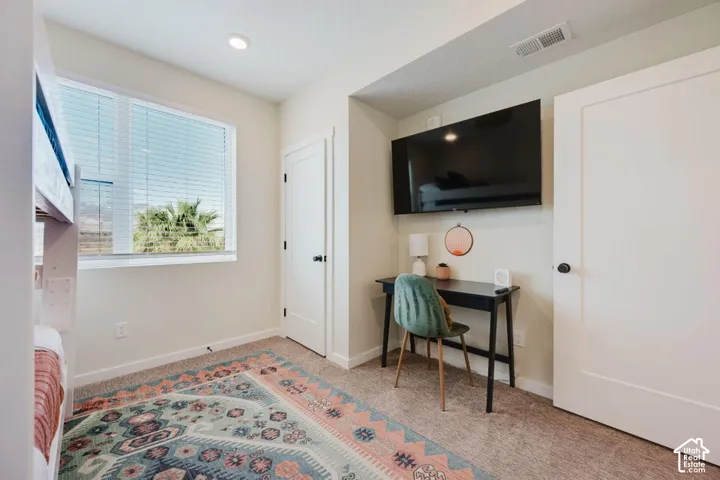 Room featuring neutral wall tones, carpeted flooring, a recessed wall niche, and two solid-core interior doors with matte black hardware