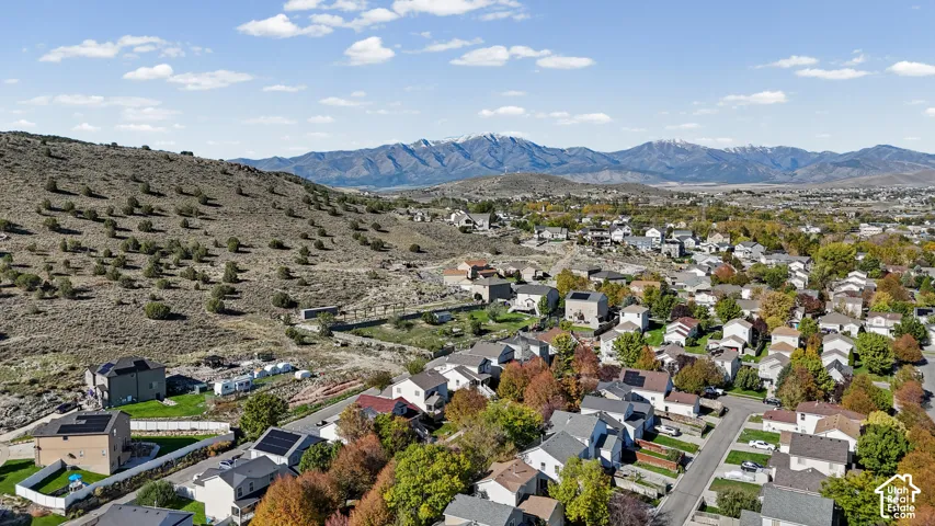 Aerial perspective featuring residential lots, paved infrastructure, and a prominent mountain range backdrop