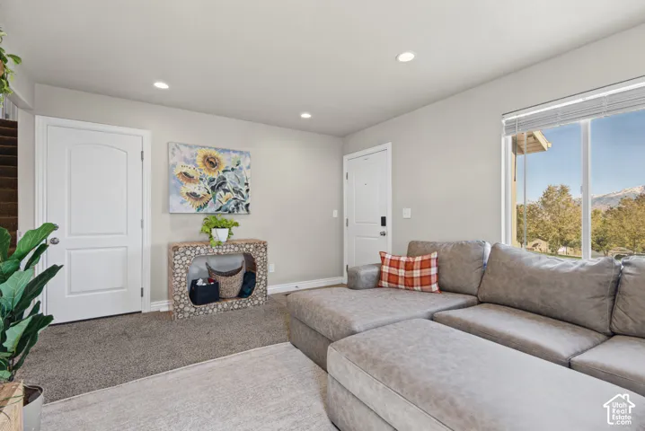 Neutral-toned interior featuring recessed lighting, a large window with natural lighting, and a mountain backdrop