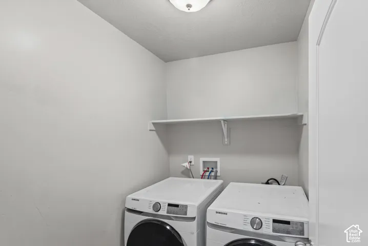 Utility area featuring a wall-mounted shelving unit, flush-mount ceiling lighting, and integrated laundry connections
