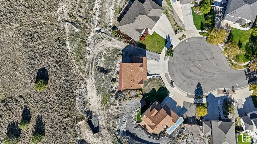 Aerial perspective featuring a residential lot situated on a cul-de-sac with natural desert landscape and paved street access