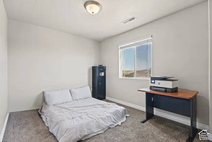 Neutral-toned walls, carpeted flooring, window with blinds, and flush-mount ceiling light