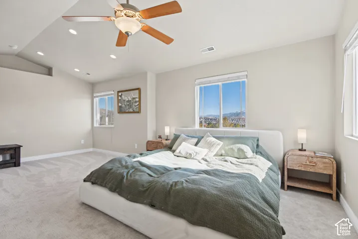 Vaulted ceiling featuring recessed lighting and a central ceiling fan, neutral wall tones, and carpeted flooring