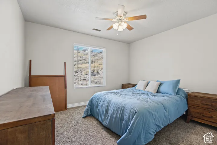 Neutral-toned walls with carpeted flooring, a ceiling fan with integrated lighting, and a window with horizontal blinds
