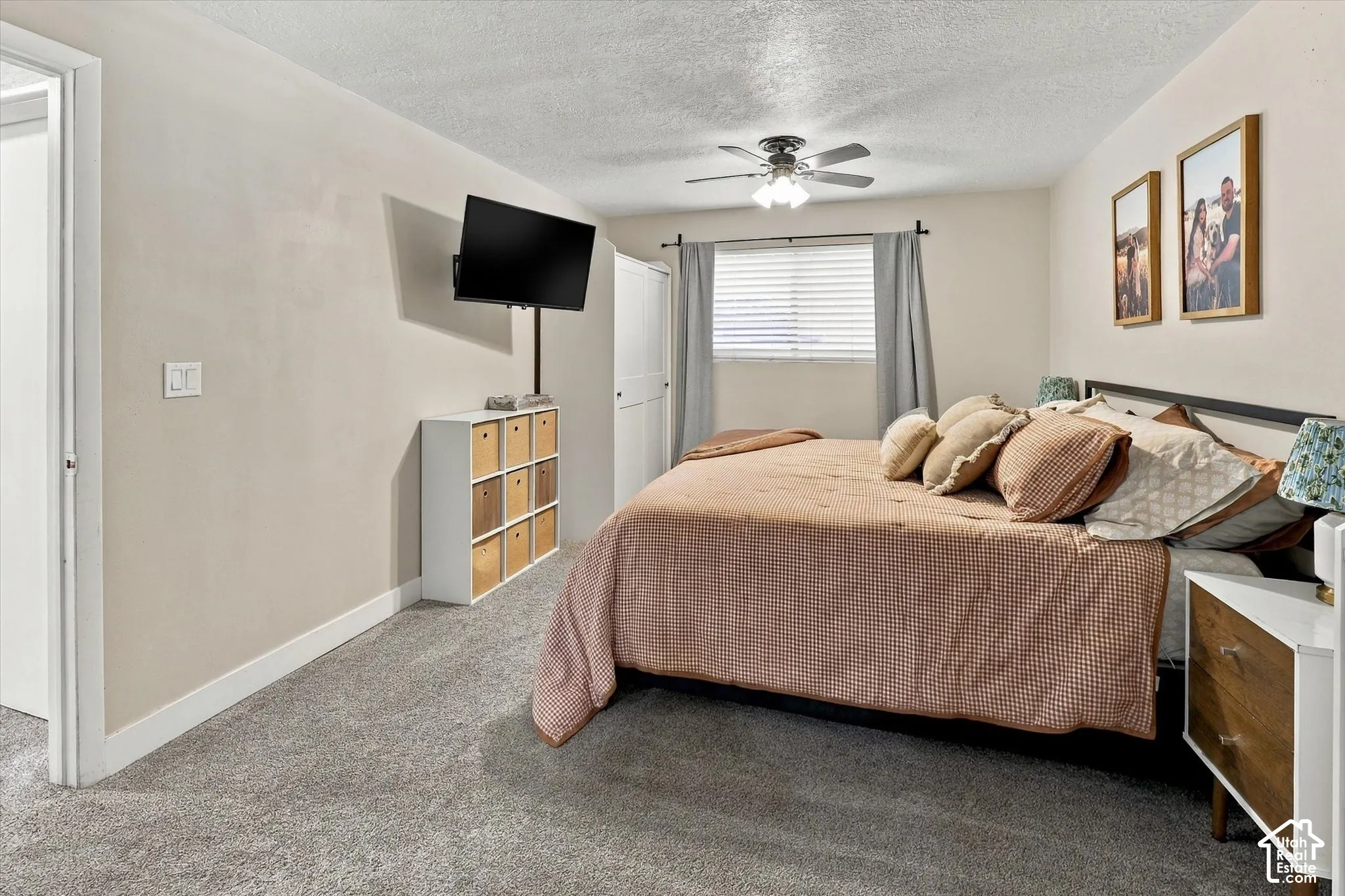 Neutral-toned carpet, ceiling fan with integrated lighting, and horizontal window blinds