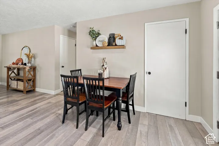 Wood-finish flooring, neutral wall tones, and a wall-mounted wood shelf