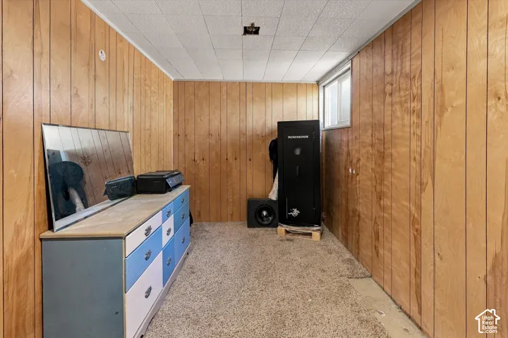 Wood paneling, drop ceiling, and carpeted flooring with a window providing natural light