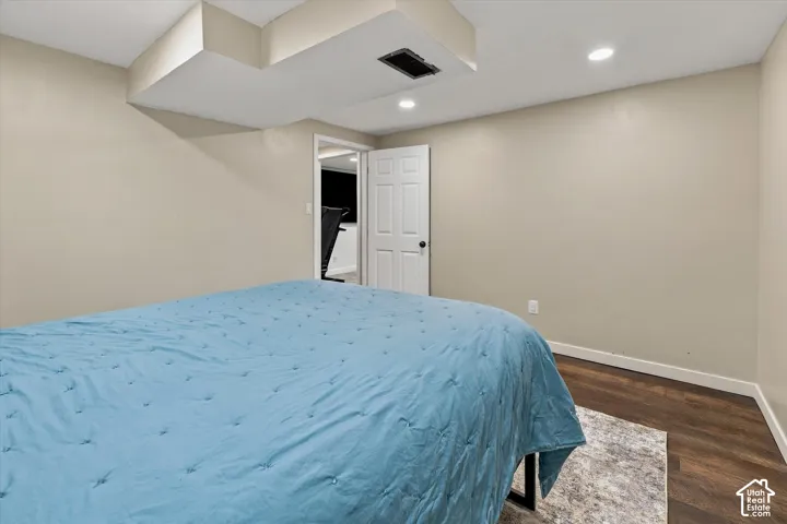 Room featuring dark-tone wood-finish flooring, recessed lighting, and a six-panel interior door