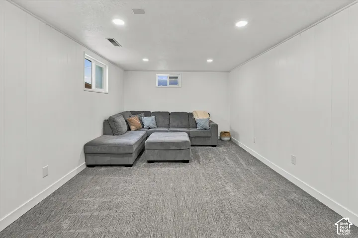 Interior room featuring neutral wall paneling, recessed lighting, carpeted flooring, and two slider windows