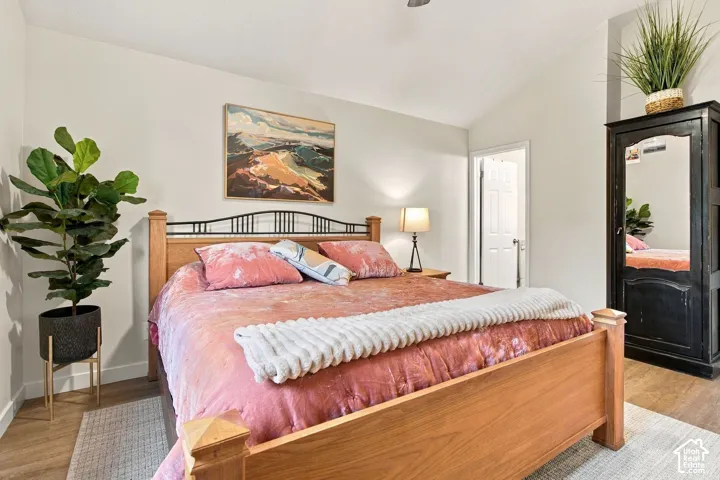 Vaulted ceilings, wood-finish flooring, and neutral wall tones