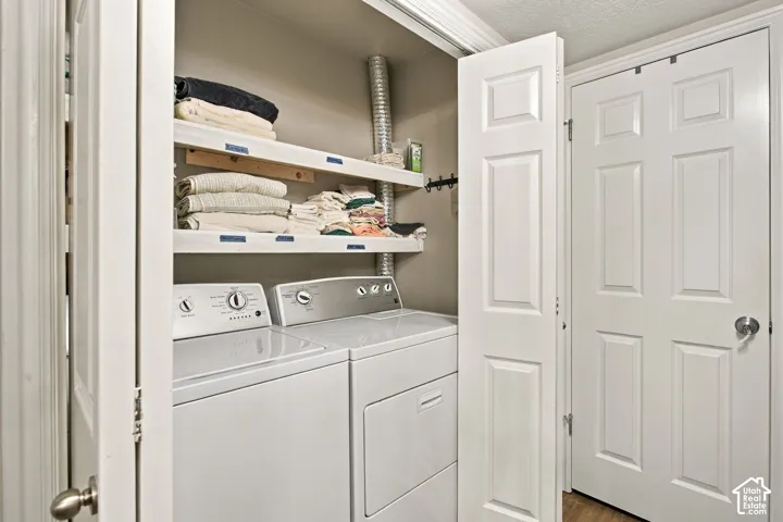 Dedicated laundry area featuring dual bi-fold doors, two-tier white shelving, and a six-panel interior door