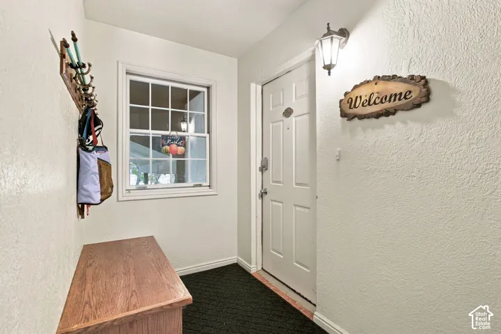 Entry area featuring a paneled door, a multi-pane grid window, and a wall-mounted carriage-style lantern fixture