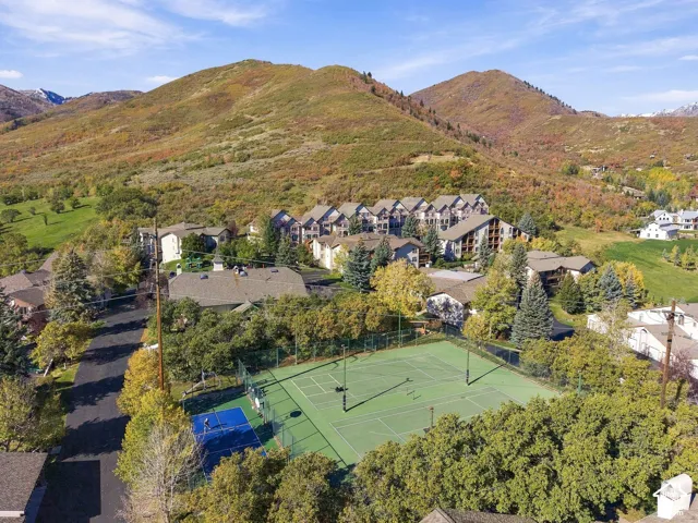 Aerial perspective featuring multi-court tennis and pickleball facilities set against a mountainous backdrop with expansive natural landscaping