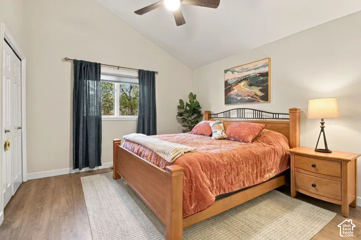 Vaulted ceilings, wood-finish flooring, and ceiling fan with integrated lighting