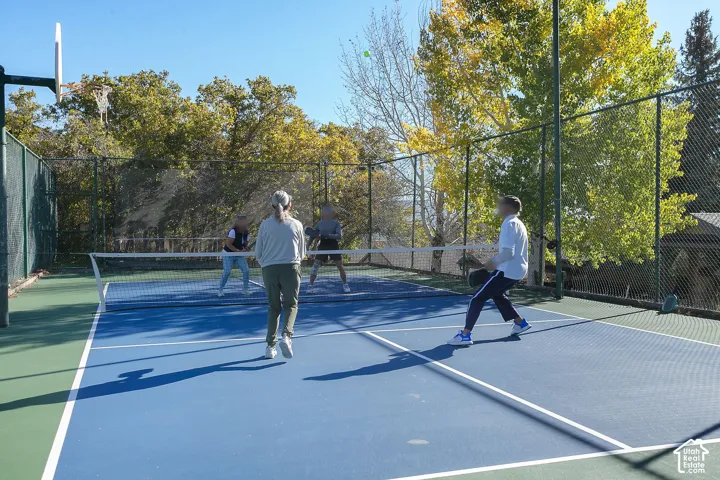 Private sports court featuring a multi-sport surface, chain-link perimeter fencing, and a built-in basketball hoop