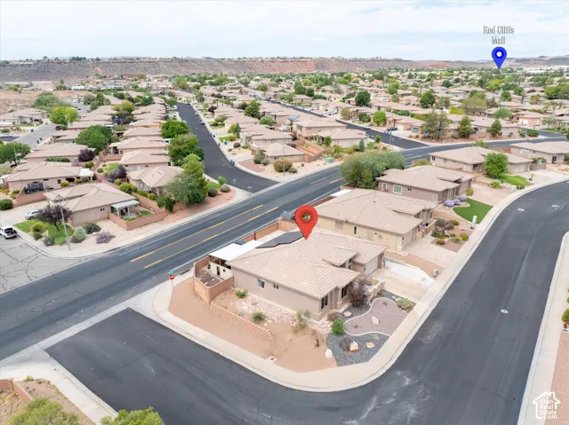 Corner lot residence featuring a tile roof, paved driveway, two-car garage, and desert-inspired landscaping