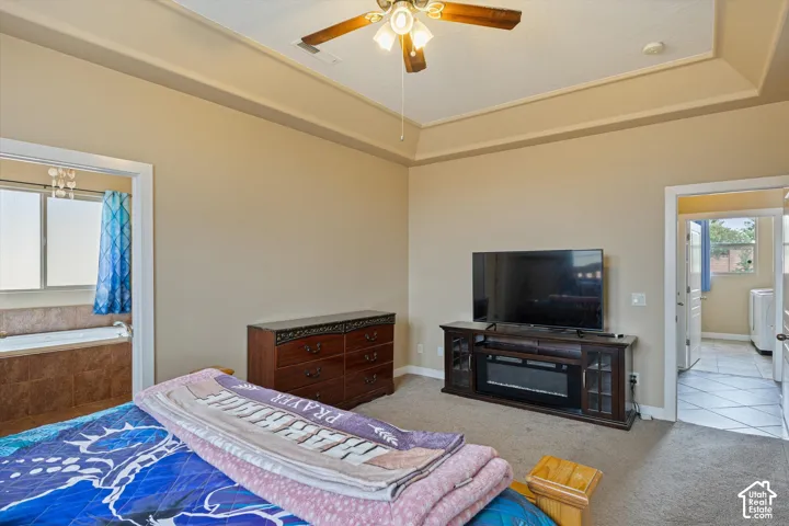 Tray ceiling with integrated crown molding and central ceiling fan with light fixture