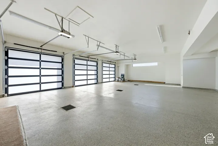 Spacious garage featuring three modern sectional doors with frosted panels