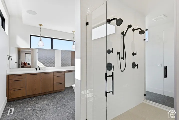 Spa-inspired bathroom featuring a glass-enclosed shower with multiple matte black shower heads
