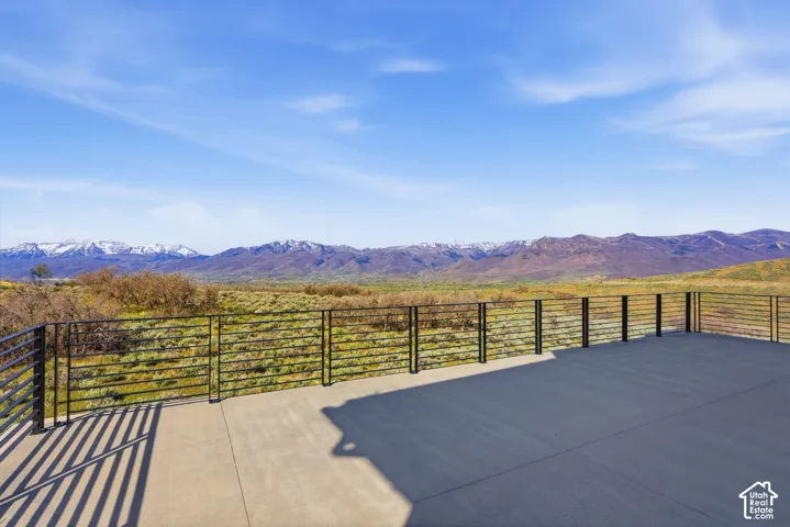 Spacious outdoor patio with a concrete surface and a sleek horizontal metal railing