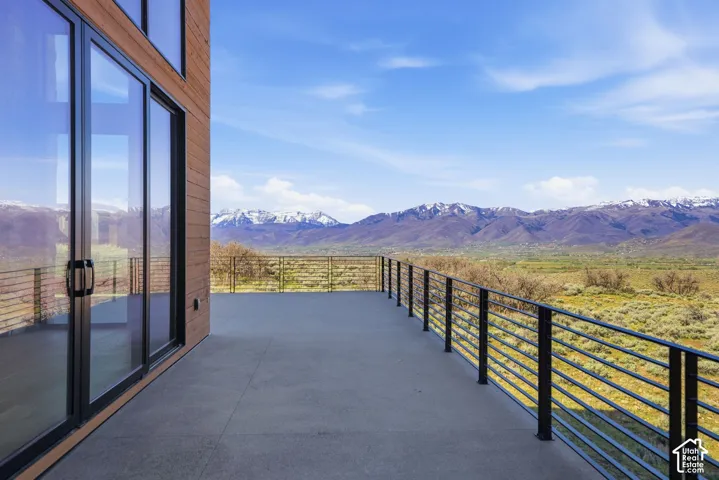 Expansive outdoor patio with a concrete surface and black metal horizontal bar railing