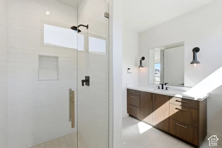 Modern bathroom featuring a glass-enclosed shower with white subway tile, a recessed niche, and a matte black shower head and controls