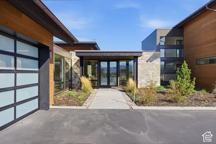 Modern architectural design featuring varied facade materials including wood-finish siding, stone accents, and dark paneling
