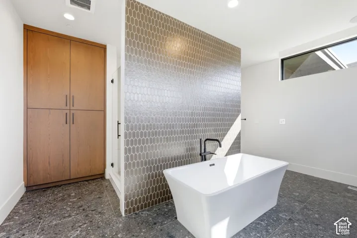 Modern bathroom featuring a freestanding soaking tub with a matte black floor-mounted faucet