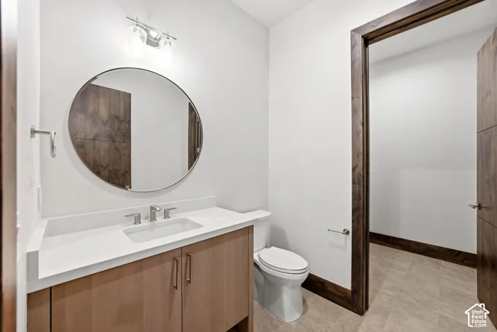 Modern vanity with a light wood-finish, white countertop, and brushed nickel fixtures