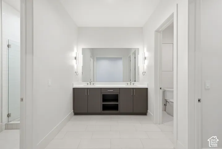 Double vanity with undermount sinks, stone countertop, and contemporary sconce lighting