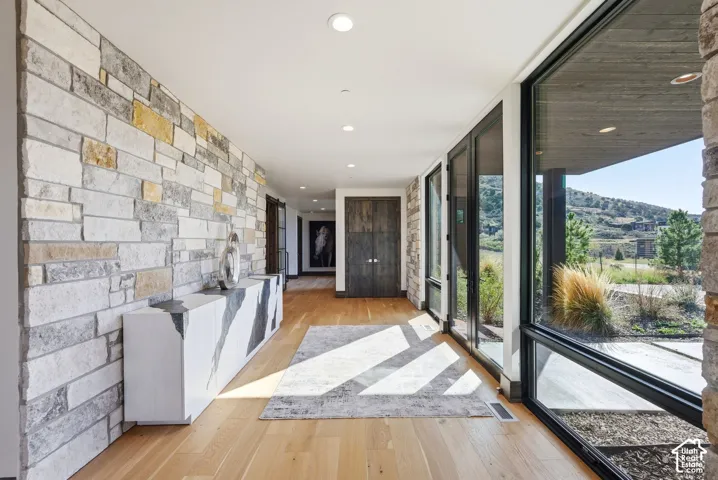 Entryway featuring a stone accent wall, light wood-finish flooring, and recessed ceiling lights