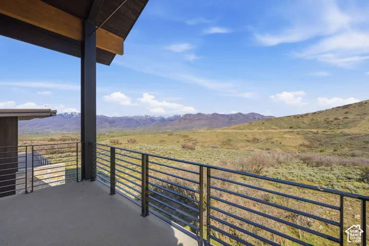 Outdoor balcony featuring a concrete surface and black metal horizontal railings