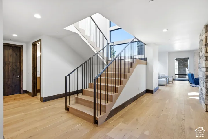 Contemporary staircase with light wood steps and black metal railings