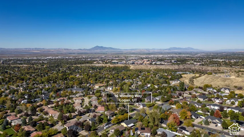 Aerial perspective featuring mature tree-lined streets and a prominent mountain range backdrop