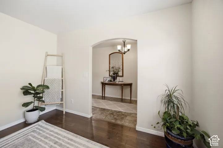 Arched doorway featuring wood-finish flooring and stone-finish tile flooring
