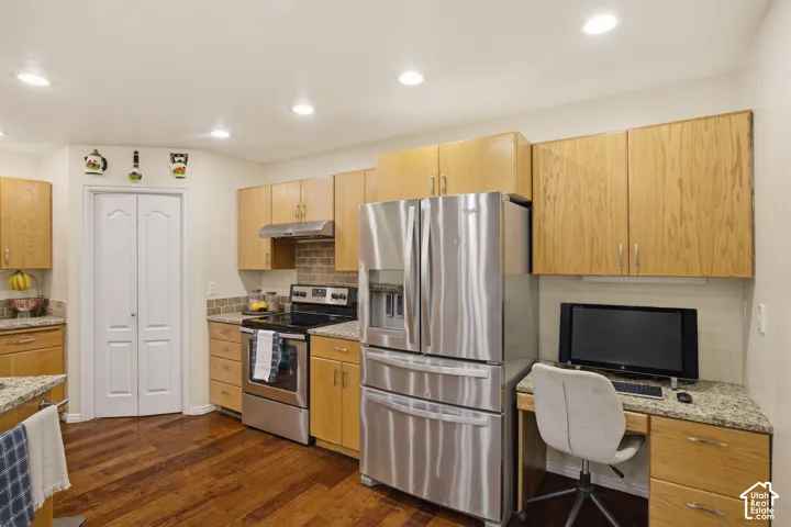 Kitchen featuring stainless steel appliances, light-toned wood cabinetry, stone-finish countertops, recessed lighting, and wood-finish flooring