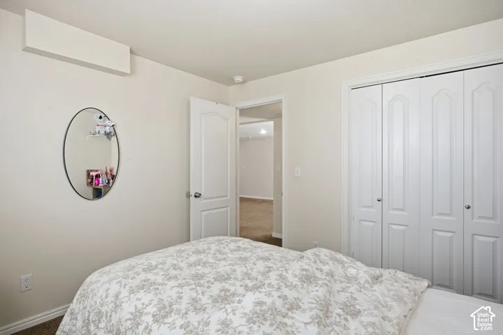 Interior room featuring a white bifold closet door, a flush-mount interior door, and a wall-mounted oval mirror