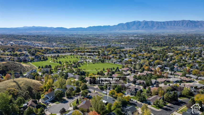 Aerial perspective showcasing the property surroundings, featuring expansive mountain backdrops and established residential landscaping