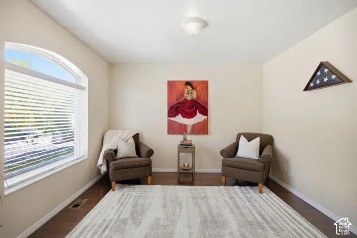 Interior space featuring wood-finish flooring, neutral wall paint, and a prominent arched window with white trim