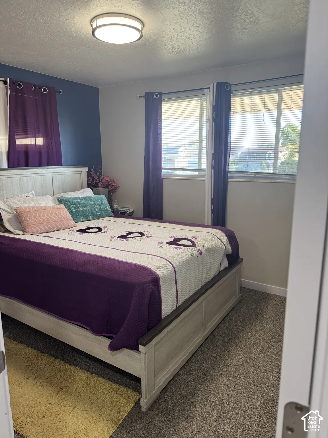 Room featuring carpeted flooring, a ceiling-mounted flush light fixture, and horizontal window blinds