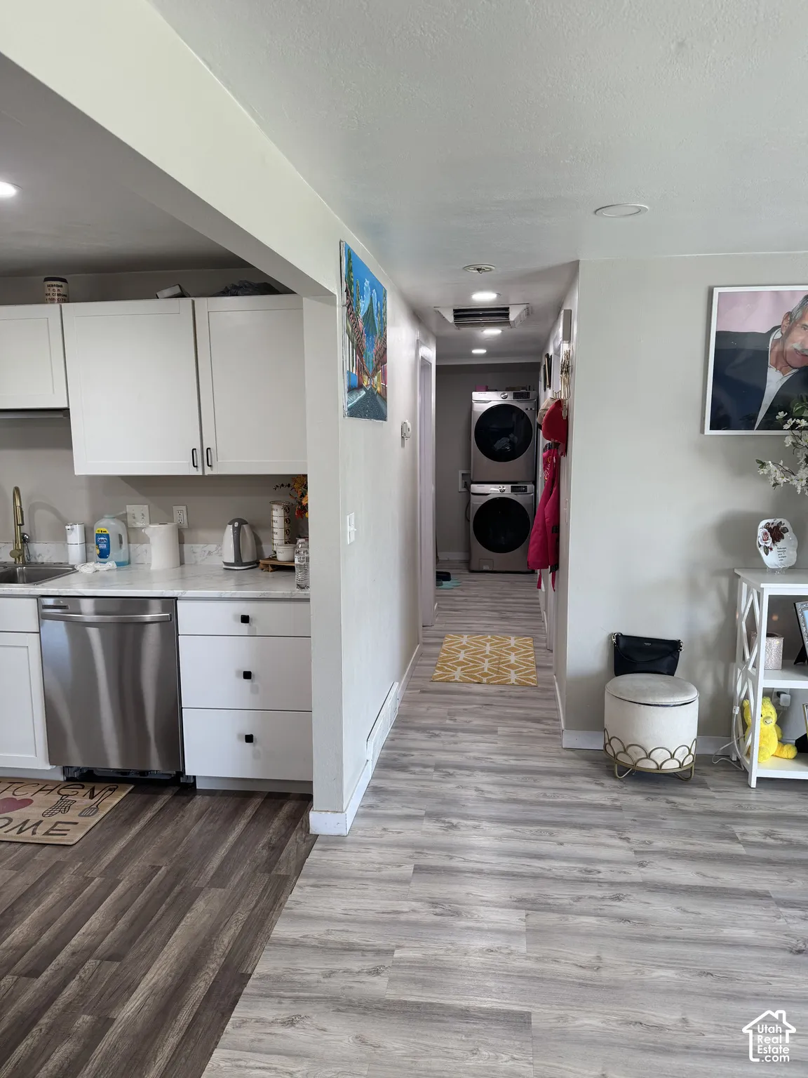 Kitchen featuring white cabinetry, light-toned countertops, and stainless steel dishwasher on main floor.