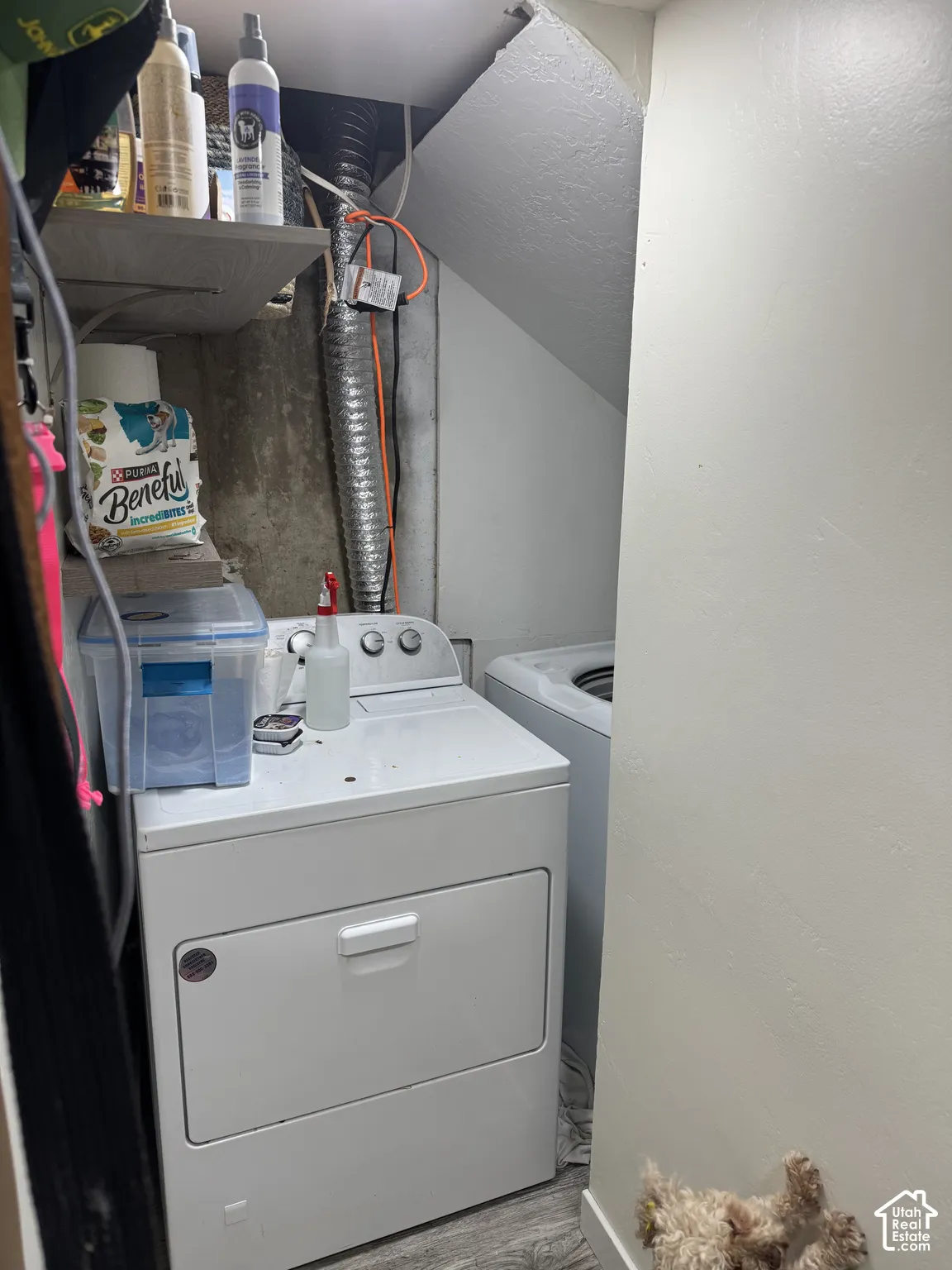 Laundry in basementbalcove featuring wood-finish flooring and built-in shelving