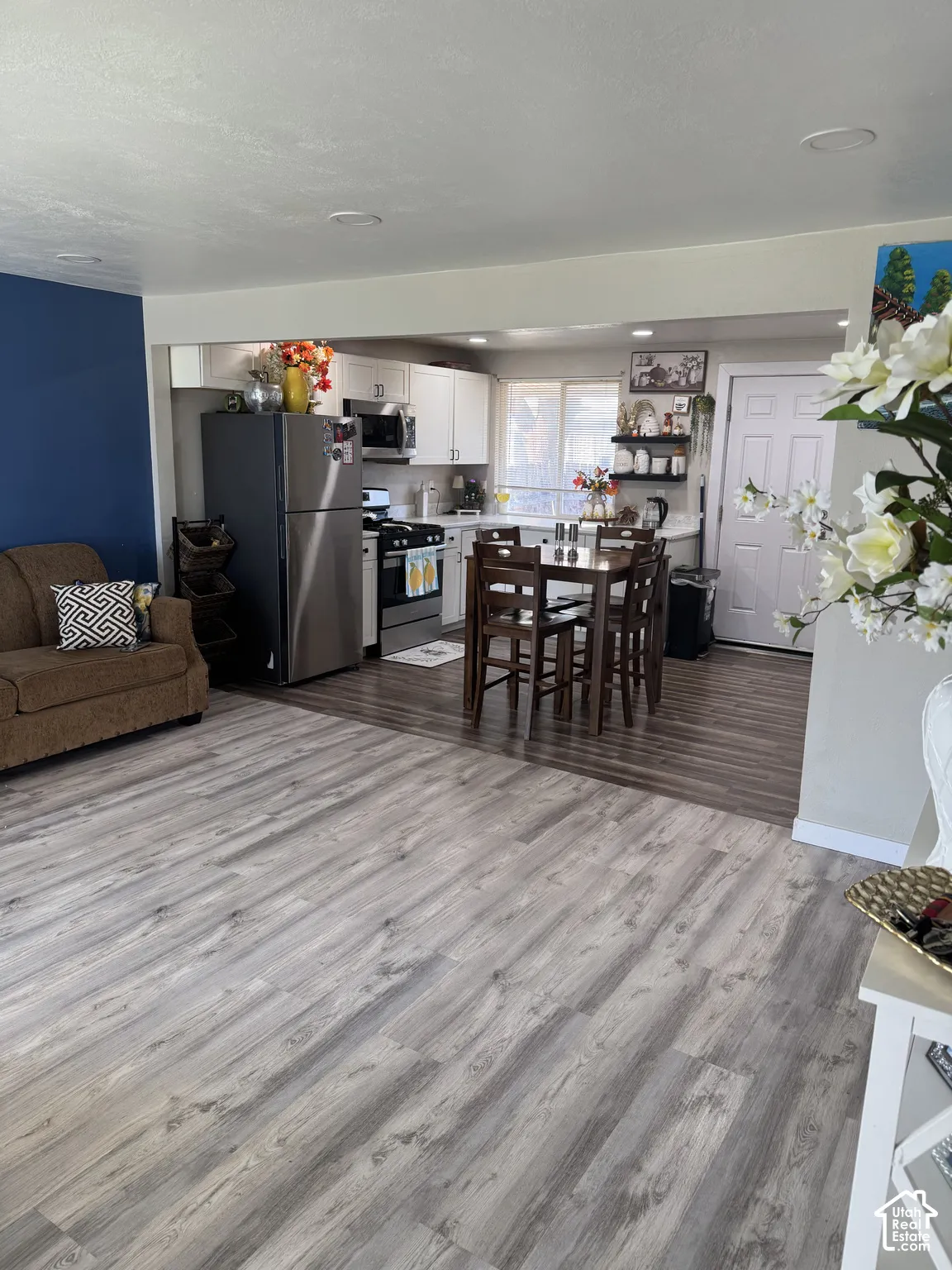 Interior space featuring wood-finish flooring, recessed lighting, and kitchen cabinetry paired with stainless steel appliances