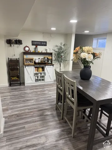 Wood-finish flooring, white built-in cabinetry featuring barn-style doors and an integrated wine rack, and recessed ceiling lighting