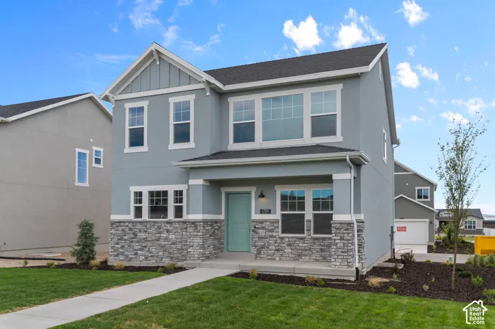 Two-story exterior featuring a stone veneer lower facade, vertical siding accents, multi-pane windows, and a covered front porch entry