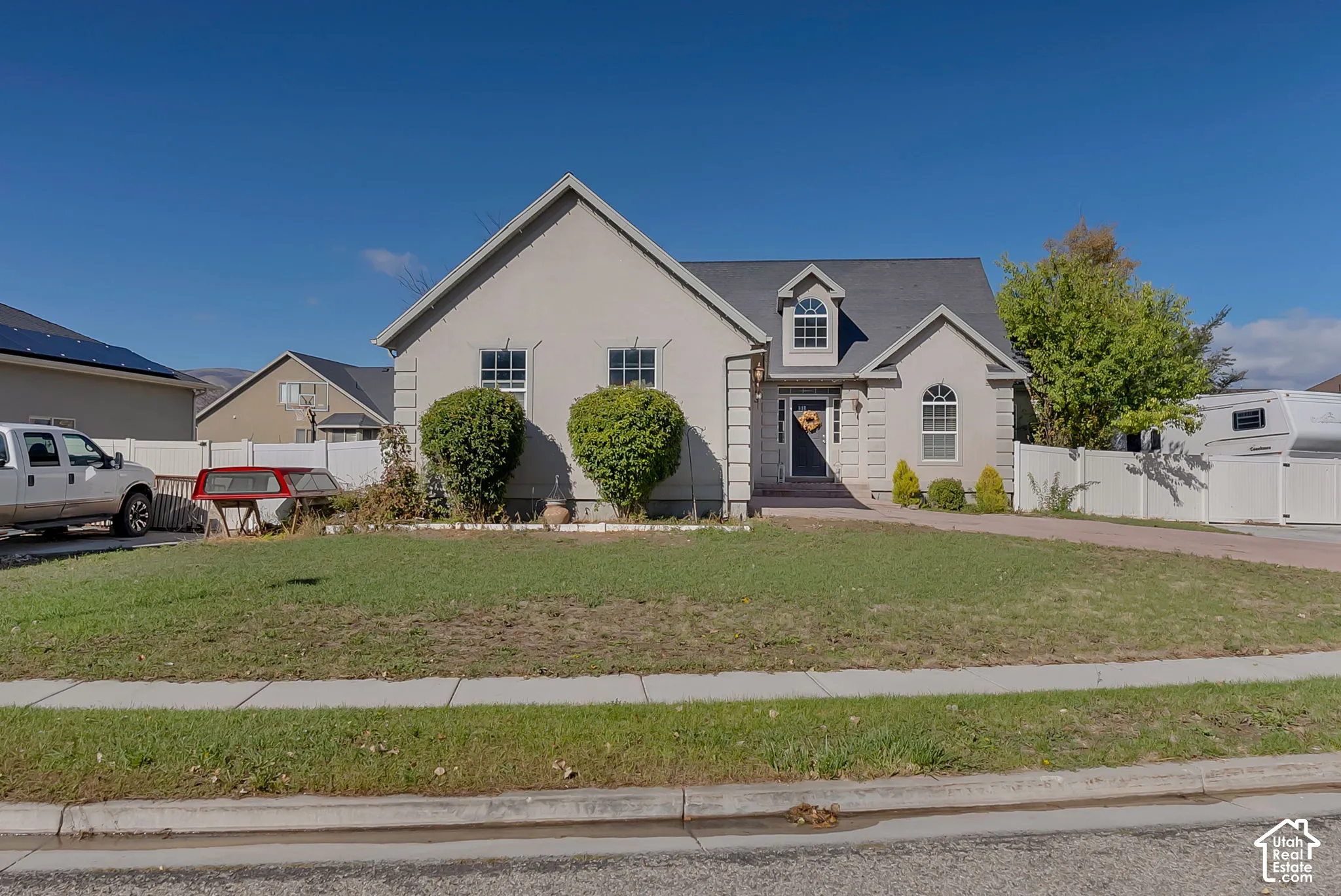 Stucco exterior featuring quoins, arched windows, a front-facing gable, and a decorative roof dormer